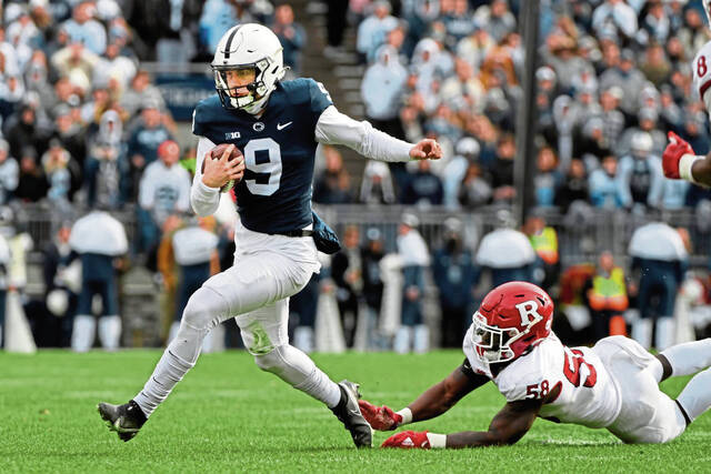 Penn State quarterback Christian Veilleux scrambles away from Rutgers linebacker Mohamed Toure during the second half in State College.