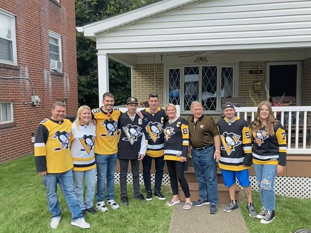 Pittsburgh Penguins captain Sidney Crosby (center) poses for a photo with the family of season ticket holder Bill Radocaj (third from right) in Coraopolis during the team’s traditional season ticket delivery event Sept. 18, 2023.
