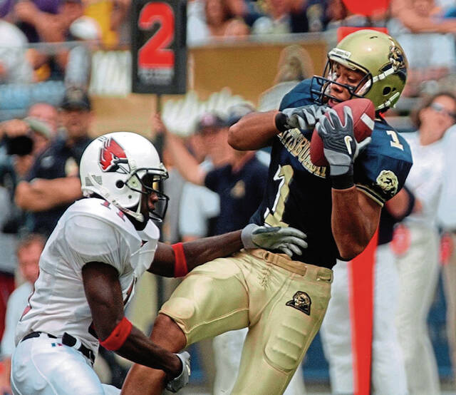 Pitt receiver Larry Fitzgerald catches a pass as Ball State’s Quentin Manley defends during the first quarter Sept. 13, 2003, at Heinz Field.