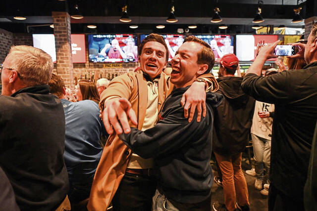 Duquesne fans Dave Negroni (left) and Greg Gurcak, both of the South Side, celebrate in the final minutes of the Dukes’ game against BYU in the first round of the NCAA Tournament during a watch party at Mike’s Beer Bar on Pittsburgh’s North Shore on Thursday, March 21, 2024. Thursday’s game marked Duquesne’s first NCAA Tournament appearance since 1977.