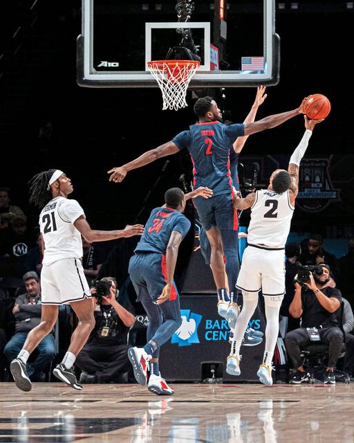 Duquesne’s David Dixon blocks the shot of VCU’s Zeb Jackson during the Atlantic 10 Tournament championship game Sunday.