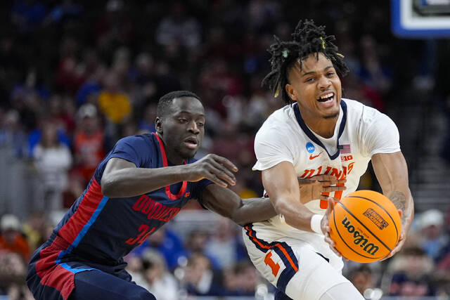 Duquesne forward Fousseyni Drame (left) reaches around Illinois guard Terrence Shannon Jr. (0) to try to knock the ball away in the first half Saturday.