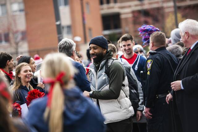 Duquesne players and Dru Joyce make their way to their buses for their road trip to Nebraska for the first round in the NCAA Tournament on March 19, 2024, along Magee Street on Duquesne’s campus in Pittsburgh.