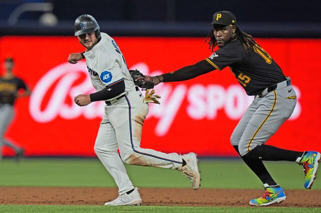 Pittsburgh Pirates shortstop Oneil Cruz, right, tags out Miami Marlins’ Jake Burger as he attempts to run to third during the third inning of a baseball game, Thursday, March 28, 2024, in Miami.