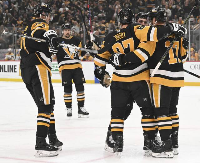 The Penguins celebrate with Sidney Crosby after Crosby’s diving goal again the Predators in the first period Monday, at PPG Paints Arena.