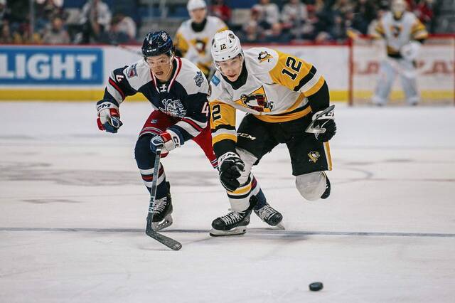 Hartford Wolf Pack defenseman Bryan Yoon and Wilkes-Barre/Scranton Penguins forward Corey Andonovski race for a puck during a game at the XL Center in Hartford, Conn. on Friday. The Wolf Pack won, 3-2.