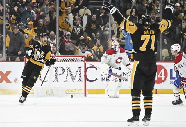 The Penguins’ Evgeni Malkin celebrates with Marcus Pettersson after Pettersson scored the game-winning goal in overtime to beat the Canadiens on Jan. 27, 2024, at PPG Paints Arena.