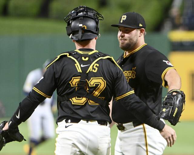 Pirates closer David Bednar celebrates with catcher Henry Davis after defeating the Brewers on Monday.