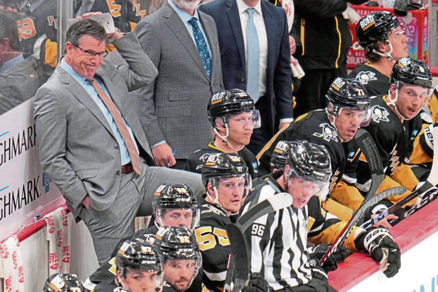 Penguins head coach Mike Sullivan (left) stands behind his bench during the third period of a March 14 game against the San Jose Sharks in Pittsburgh.