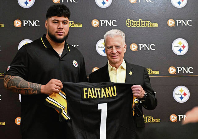 The Steelers’ first-round pick Troy Fautanu poses with Art Rooney II on Friday at UPMC Rooney Sports Performance Complex.