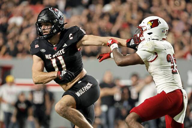 North Carolina State linebacker Payton Wilson (11) stiff arms Louisville running back Isaac Guerendo (23) during the first half of an NCAA college football game in Raleigh, N.C., Friday, Sept. 29, 2023.