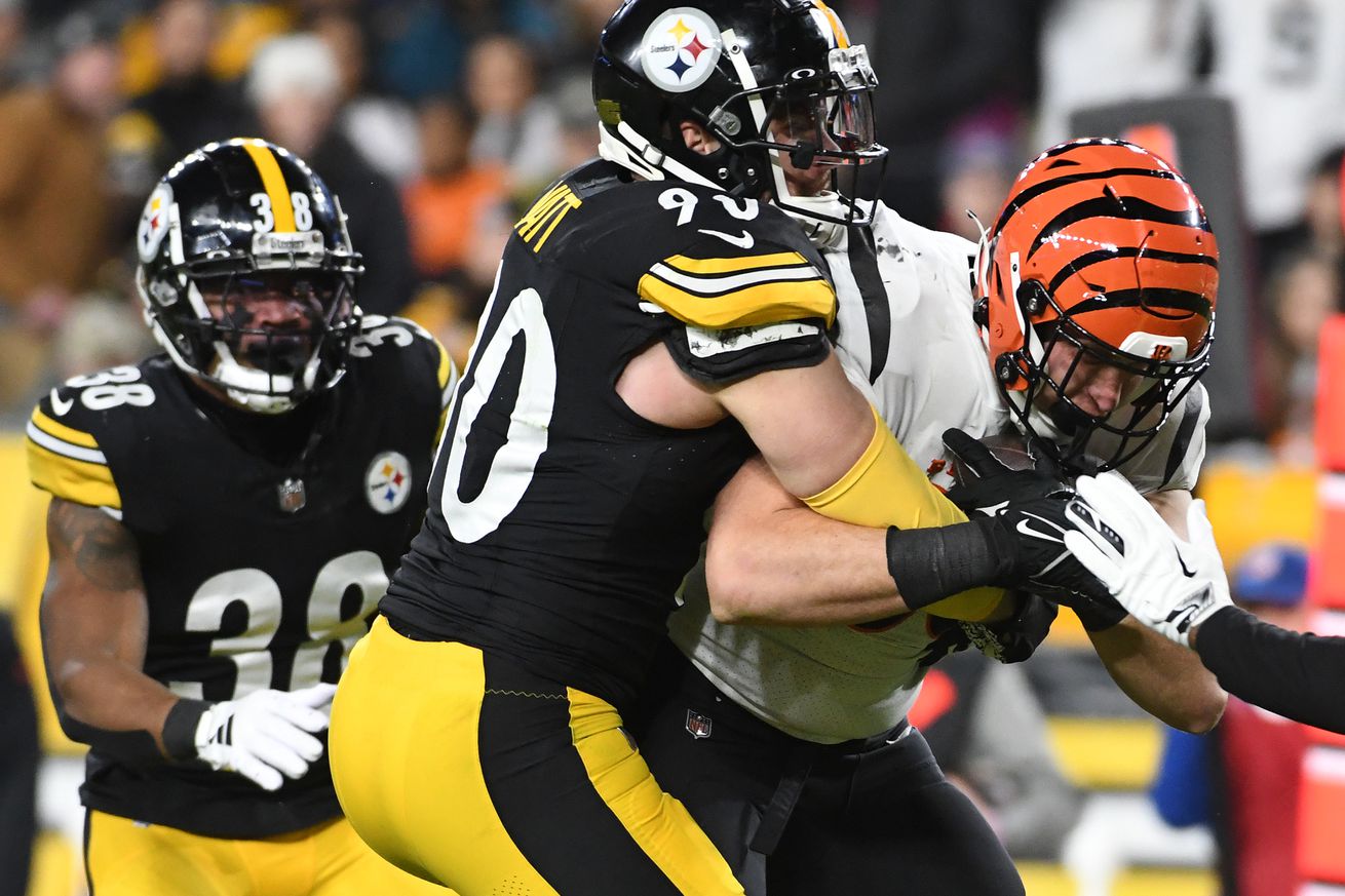 Pittsburgh Steelers linebacker T.J. Watt brings down Cincinnati Bengals tight end Drew Sample during a 2023 regular season contest from Acrisure Stadium.