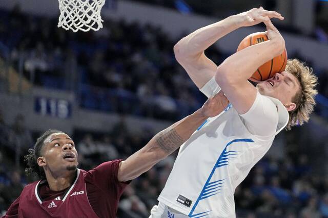 Saint Louis’ Stef Van Bussel (15), right, and Massachusetts’ Daniel Hankins-Sanford reach for a rebound during the second half of an NCAA college basketball game Saturday, Jan. 27, 2024, in St. Louis.