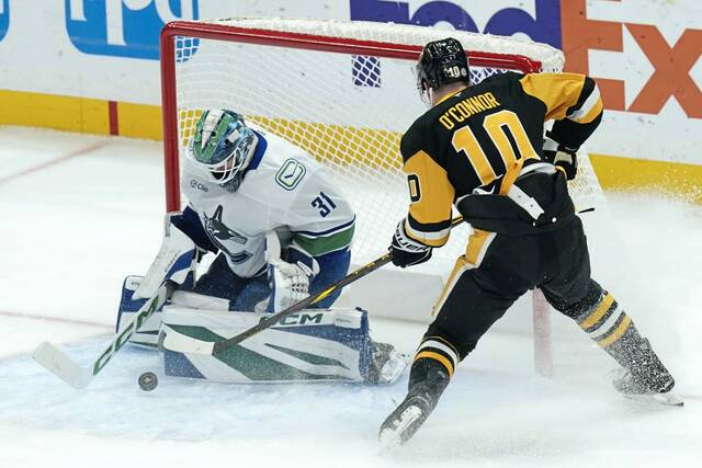 Vancouver Canucks goaltender Arturs Silovs (31) makes a save against Pittsburgh Penguins’ Drew O’Connor (10) during the first period of an NHL hockey game Wednesday, Nov. 27, 2024, in Pittsburgh.