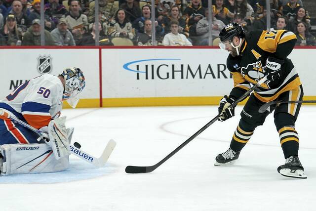 New York Islanders goaltender Marcus Hogberg makes a save against Penguins forward Bryan Rust during a game at PPG Paints Arena on Dec. 29, 2024.