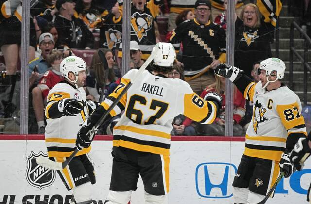 Pittsburgh Penguins right wing Bryan Rust (17) celebrates with right wing Rickard Rakell (67) and center Sidney Crosby (87) after scoring a goal during the first period of an NHL hockey game against the Florida Panthers, Sunday, March 23, 2025, in Sunrise, Fla.