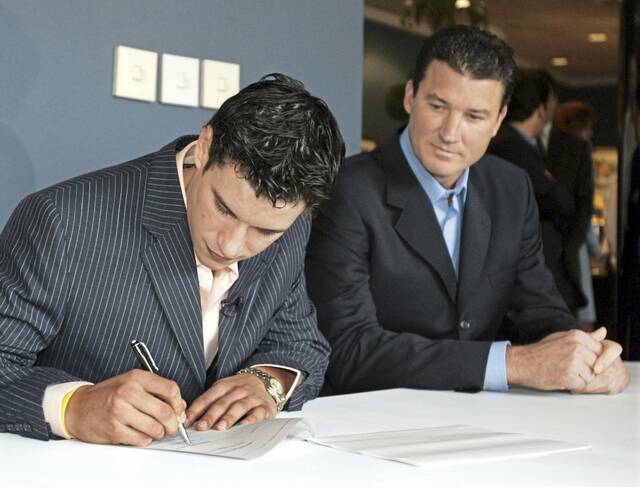 From Sept. 9, 2005: Penguins’ No. 1 draft pick Sidney Crosby signs his new contract as team owner and player Mario Lemieux watches on during a news conference in Pittsburgh.