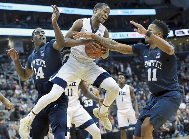Pittsburgh’s Justice Kithcart (5) holds onto the ball as Penn State’s Mike Watkins (24) and Lamar Stevens (11) try to make a steal during the first half of an NCAA college basketball game Saturday, Dec. 10, 2016, in Newark, N.J.