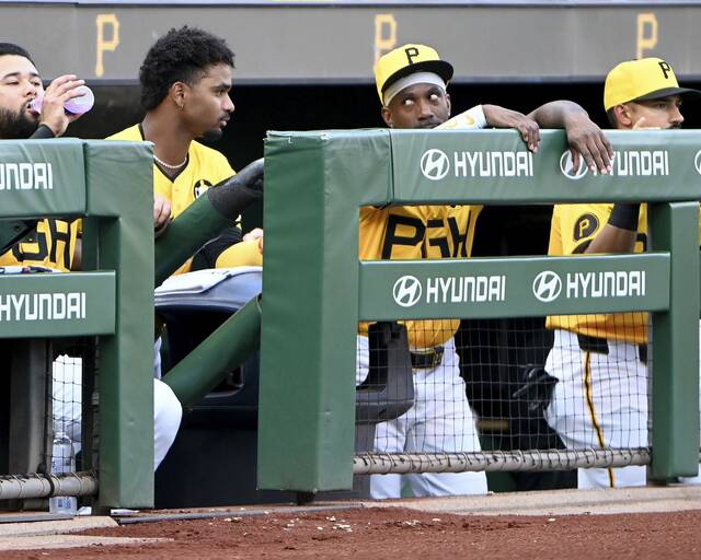 Pirates infielder Liover Peguero talks with Andrew McCutchen in the dugout during their game against the Reds on Friday, Aug. 8, 2025, at PNC Park.