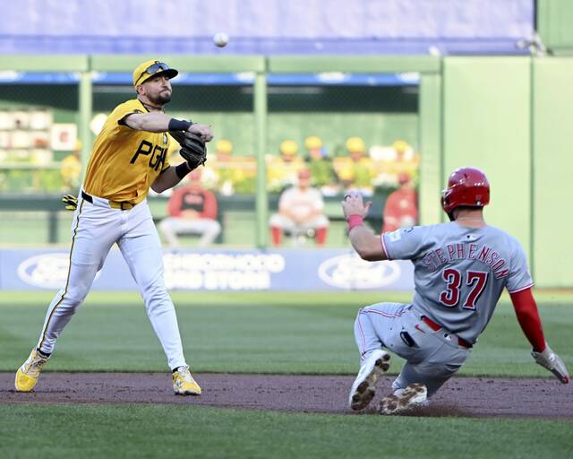 Pirates shortstop Jared Triolo turns a double play over the Reds’ Tyler Stephenson on Friday, Aug. 8, 2025, at PNC Park.