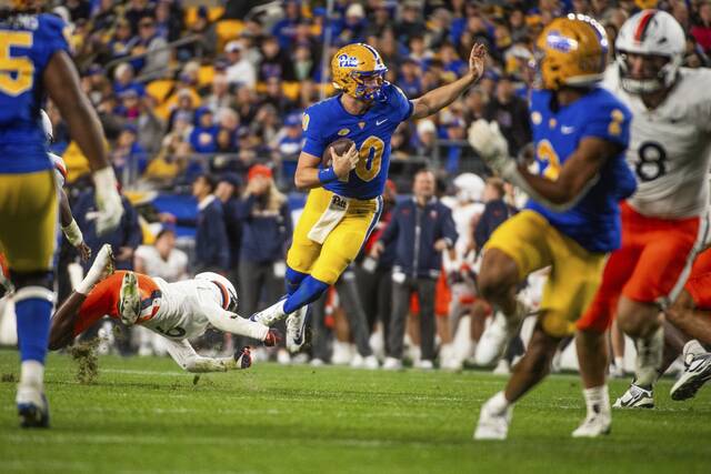 Pitt’s Eli Holstein attempts to avoid a tackle by the Virginia defense on Saturday, Nov. 9, 2024 at Acrisure Stadium.
