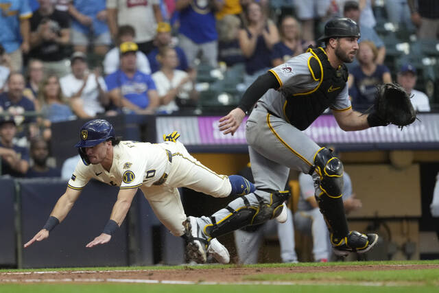 Milwaukee’s Sal Frelick slides at home to score a run past Pirates catcher Joey Bart during the third inning Monday, Aug. 11, 2025.