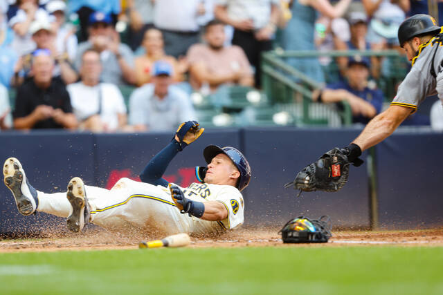 The Brewers’ Isaac Collins scores against the Pirates during the fourth inning Wednesday.