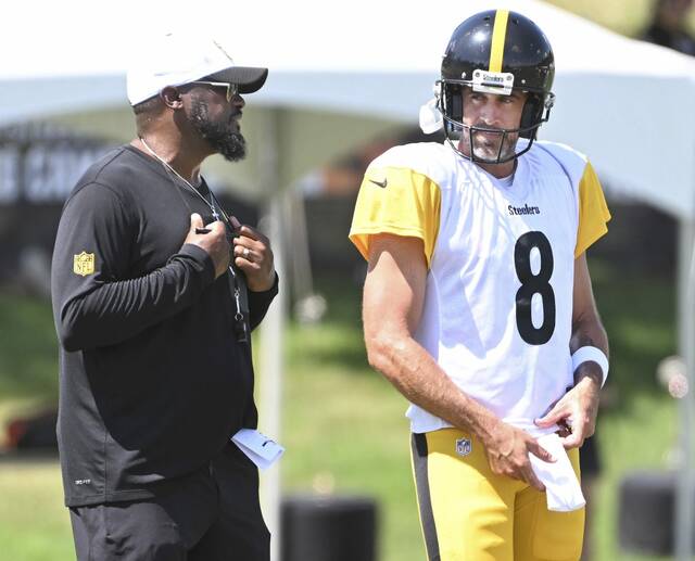 Steelers head coach Mike Tomlin talks with Aaron Rodgers on Tuesday at Saint Vincent College.