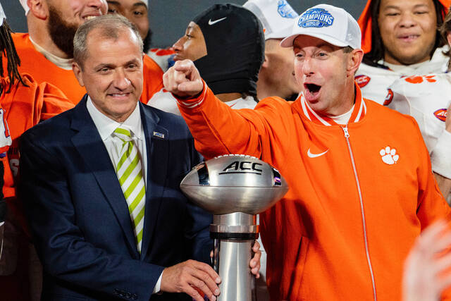 Clemson coach Dabo Swinney, with ACC commissioner Jim Phillips by his side, celebrates winning the ACC championship in December.