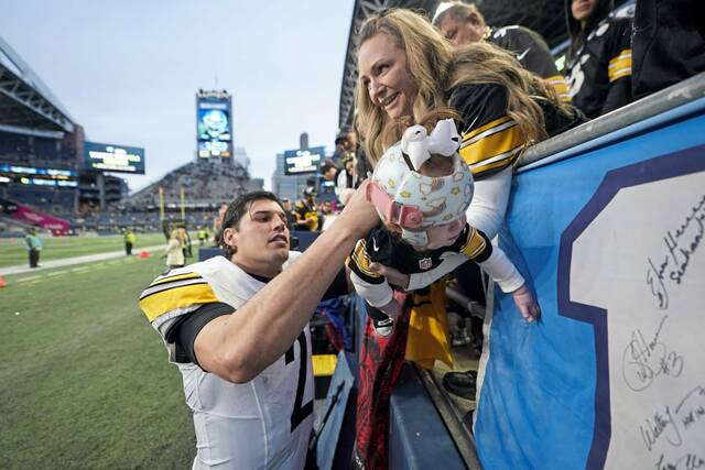 Steelers quarterback Mason Rudolph autographs a baby’s jersey after a game against the Seahawks on Dec. 31, 2023, in Seattle.