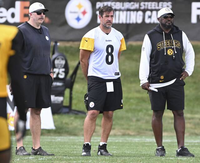 In a break from tradition for Steelers coach Mike Tomlin (right), starting quarterback Aaron Rodgers (left) will not play in the preseason.
