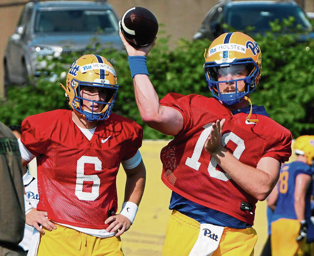 Quarterback Eli Holstein (10) passes as teammate Mason Heintschel looks on during the first day of Pitt practice July 30 at UPMC Rooney Sports Complex on the South Side.