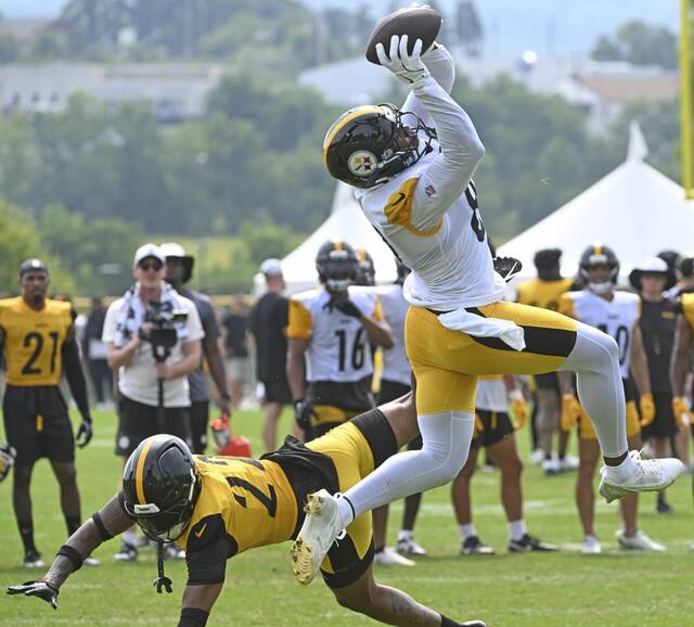 Steelers tight end Jonnu Smith pulls in a catch over Juan Thornhill on July 31, 2025, at Saint Vincent College.