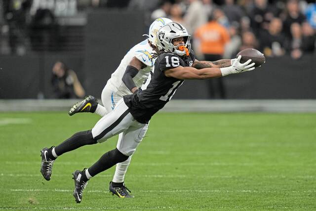 Las Vegas Raiders wide receiver Jakobi Meyers (16) catches a pass in front of Los Angeles Chargers cornerback Kristian Fulton during the first half of an NFL football game in Las Vegas, Sunday, Jan. 5, 2025.