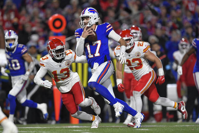 Buffalo Bills quarterback Josh Allen (17) avoids Kansas City Chiefs safety Nazeeh Johnson (13) as he runs for a touchdown during the second half of an NFL football game in Orchard Park, N.Y., Sunday, Nov. 17, 2024.