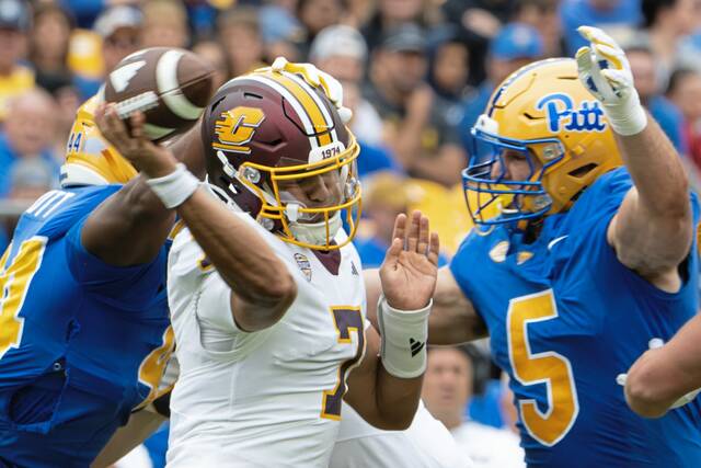 Central Michigan quarterback Angel Flores (7) is swarmed by Pitt's Jimmy Scott (left) and Zach Crothers (right) on Saturday, Sept. 6, 2025, at Acrisure Stadium.