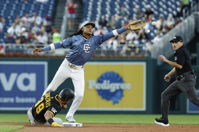 The Pirates’ Nick Gonzales advances to second base on a throwing error by Washington first baseman Josh Bell as the ball is out of the reach of Nationals shortstop CJ Abrams during the second inning Friday.