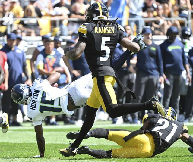 The Seahawks’ Tory Horton gains yardage Sunday over the Steelers’ Chuck Clark at Acrisure Stadium.