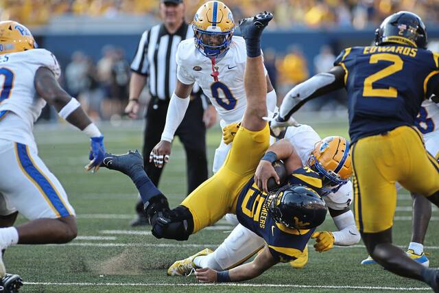 West Virginia quarterback Scotty Fox Jr. (15) is tackled by Pittsburgh linebacker Rasheem Biles (3) during the second half of an NCAA college football game Saturday, Sept. 13, 2025, in Morgantown, W.Va.