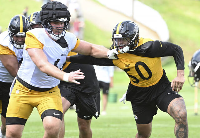 Steelers linebacker Malik Harrison (left) and offensive lineman Max Scharping fight for position during training camp July 27 at Saint Vincent College.