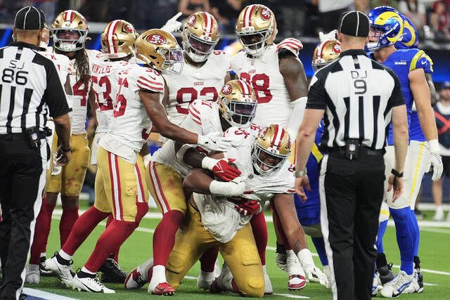 San Francisco 49ers defensive tackle Alfred Collins, bottom, celebrates with teammates after recovering a fumble against the Los Angeles Rams during the second half Thursday.