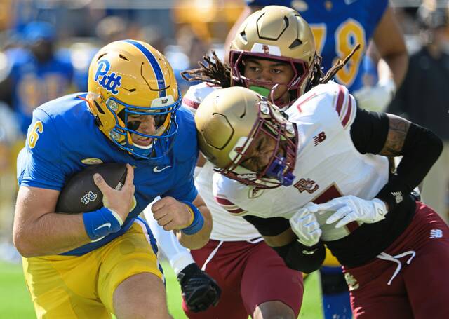 Pitt quarterback Mason Heintschel (6) lowers his shoulder as he braces for impact against Boston College's Carter Davis (7) on Saturday, October 4, 2025, at Acrisure Stadium.