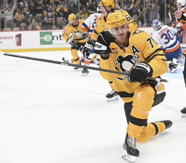 Evgeni Malkin celebrates the Penguins’ first-period goal against the Islanders on Thursday at PPG Paints Arena. The goal was later credited to Rickard Rakell.