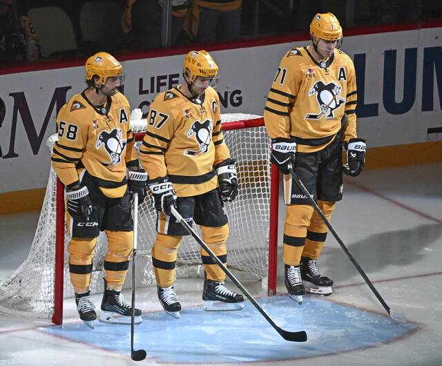 The Penguins’ Kris Letang, Sidney Crosby and Evgeni Malkin stand together for their 20th year together as they play the Islanders on Thursday. The three are wearing the team’s new alternate jerseys.