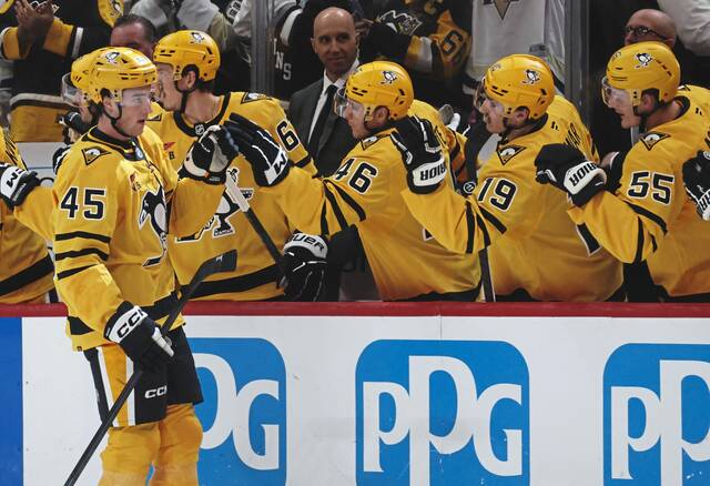 Penguins defenseman Harrison Brunicke celebrates his first NHL goal with the bench Thursday night against the New York Islanders at PPG Paints Arena.