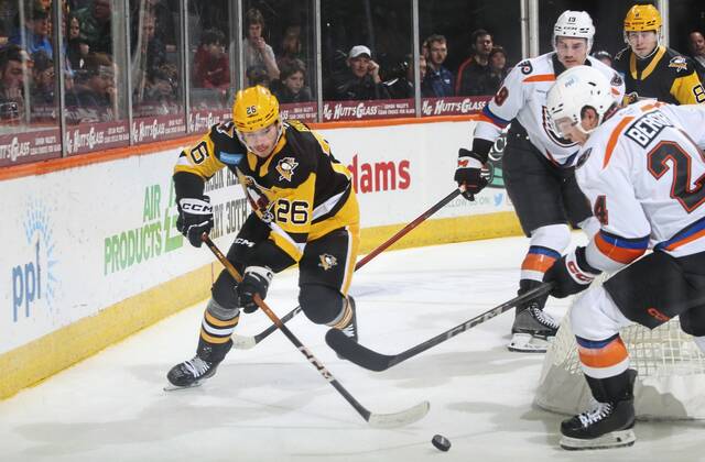 Wilkes-Barre/Scranton Penguins forward Tristan Broz (No. 26) protects the puck against Lehigh Valley Phantoms defensemen Hunter McDonald (No. 19) and Carter Berger during a game at the PPL Center in Allentown Sunday. The Penguins won, 4-1