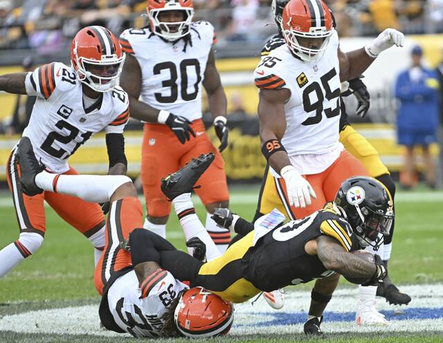Steelers running back Jalen Ramsey dives over the Browns’ Ronnie Hickman for extra yardage in the first quarter Sunday, Oct. 12, 2025, at Acrisure Stadium.