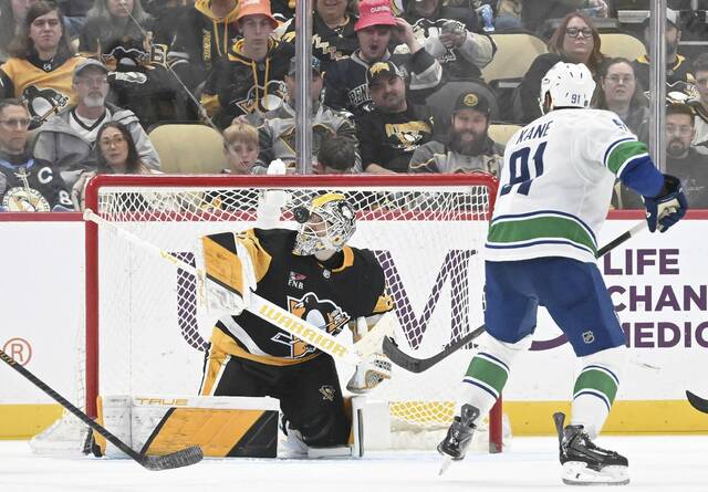 Penguins goaltender Arturs Silovs makes a save off his mask against the Canucks in the third period Tuesday.