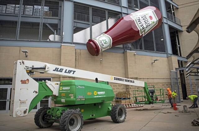 Labors work to install the Heinz ketchup bottle on Acrisure Stadium in Pittsburgh on April 18, 2023.
