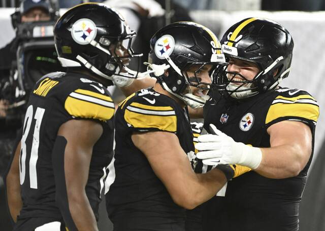 The Steelers’ Jonnu Smith and Zach Frazer celebrate with Pat Freiermuth after Freiermuth’s third-quarter touchdown against the Bengals on Oct. 16, 2025 at Paycor Stadium.